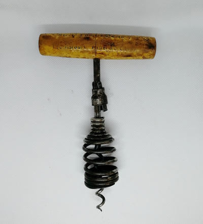 Штопор с запирающимся утройством. Оборудован Т-образной ручкой из дерева, рабочая часть оснащена проволочной спиралью, пружинной рамой и запирающимся устройством. Полностью исправен.