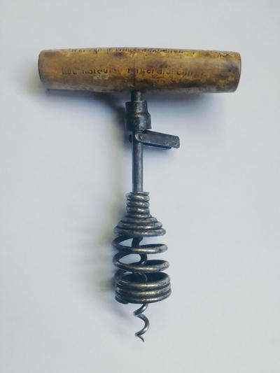 Штопор с запирающимся утройством. Оборудован Т-образной ручкой из дерева, рабочая часть оснащена проволочной спиралью, пружинной рамой и запирающимся устройством. Полностью исправен.