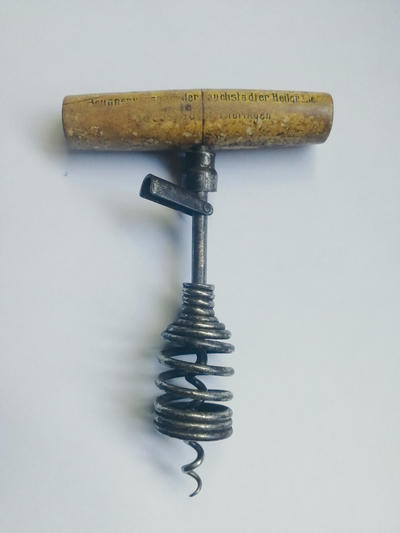 Штопор с запирающимся утройством. Оборудован Т-образной ручкой из дерева, рабочая часть оснащена проволочной спиралью, пружинной рамой и запирающимся устройством. Полностью исправен.