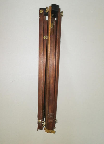 Фотокамера со штативом. Одна из ранних студийных фотокамер. На объективе ещё отсутствует механический затвор с выдержкой съемки.